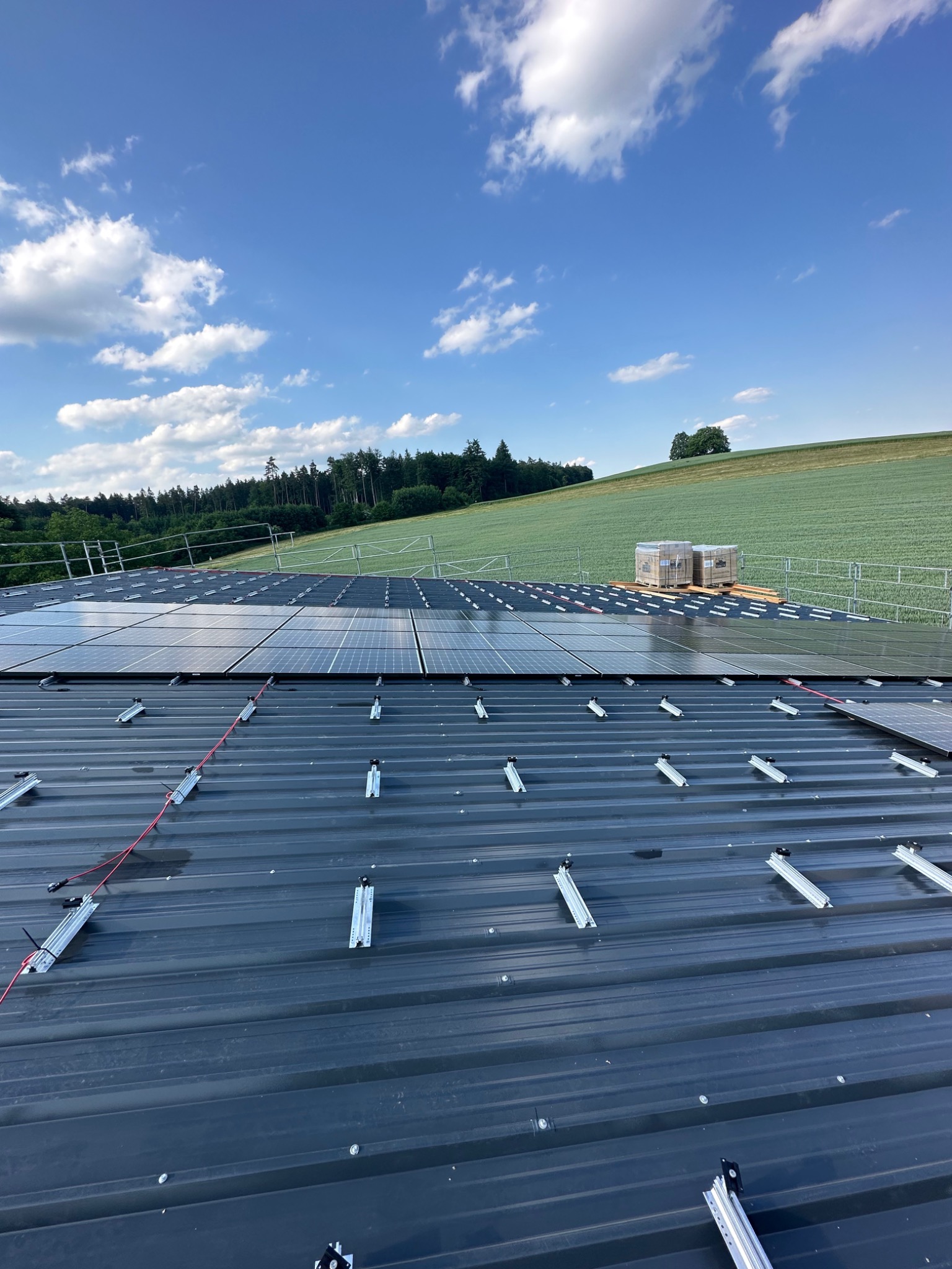 Montageprofile und bereits verlegte Solarmodule auf einem Metalldach